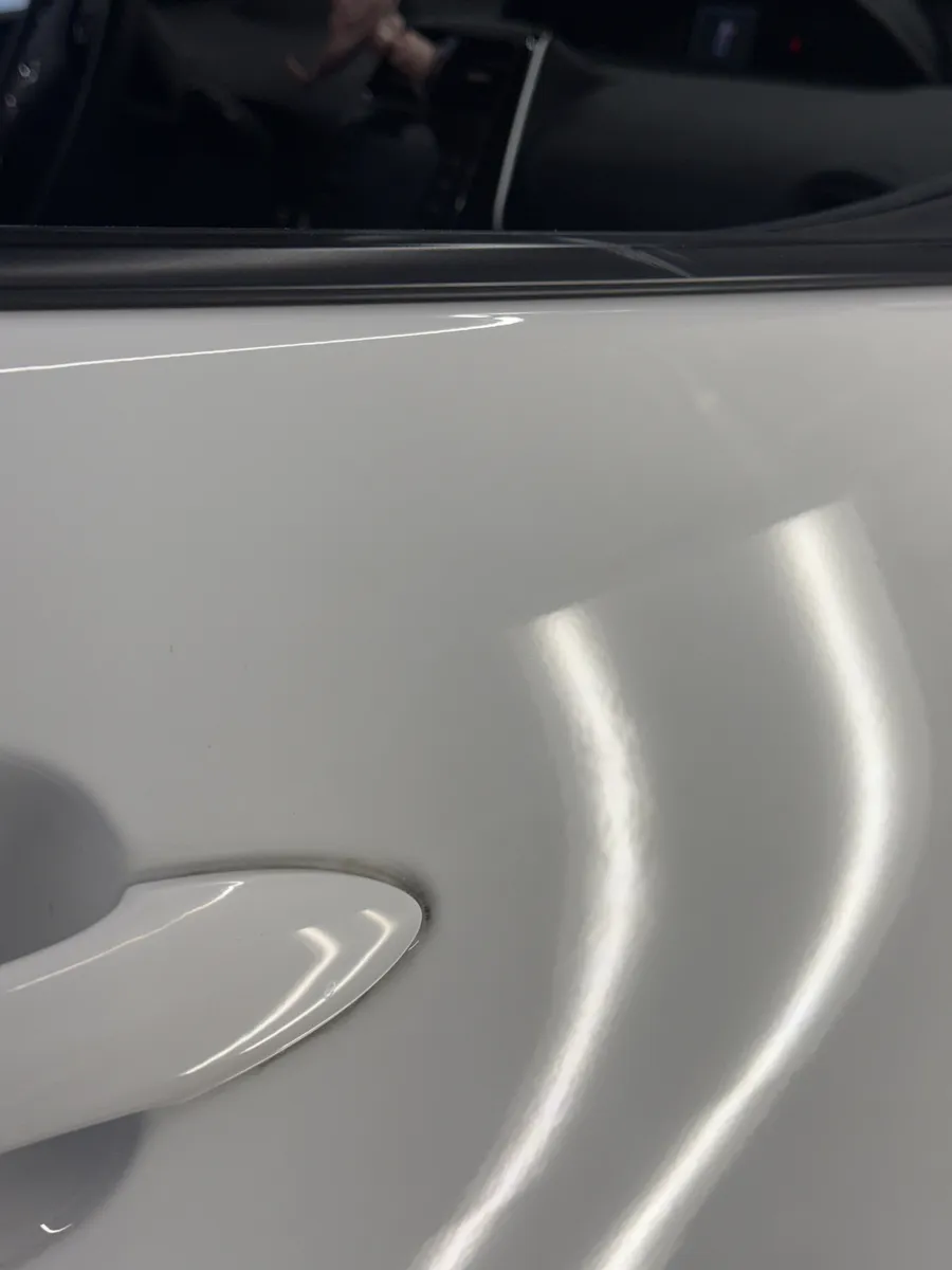 Paintless dent repair before and after on vehicle body panel in Garland TX