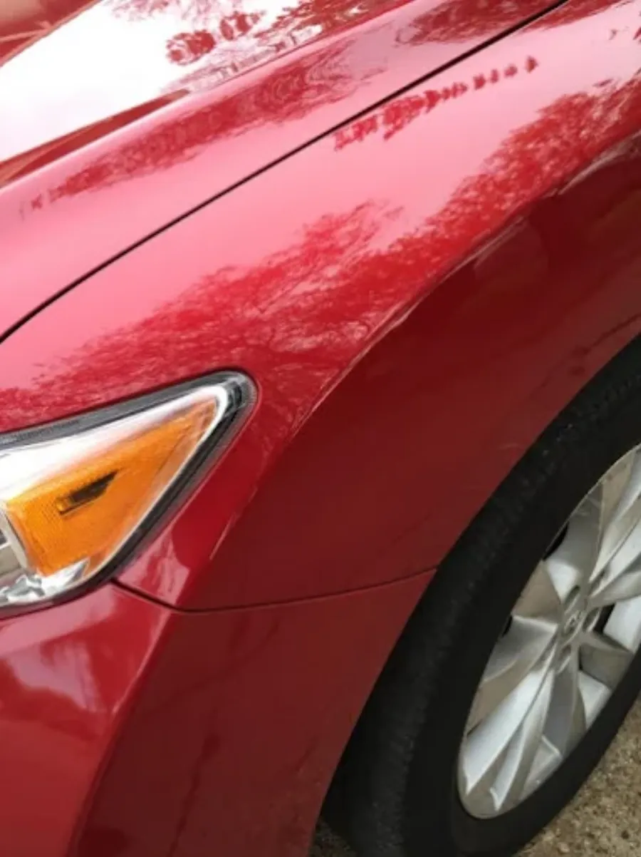Paintless dent repair before and after on red vehicle fender in Garland TX