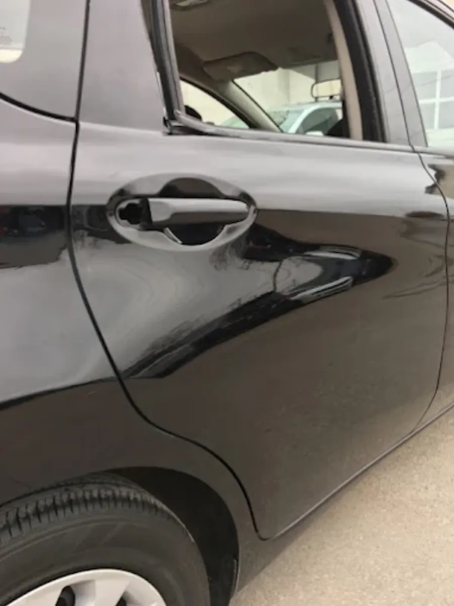 Paintless dent repair before and after on black vehicle door in Garland TX