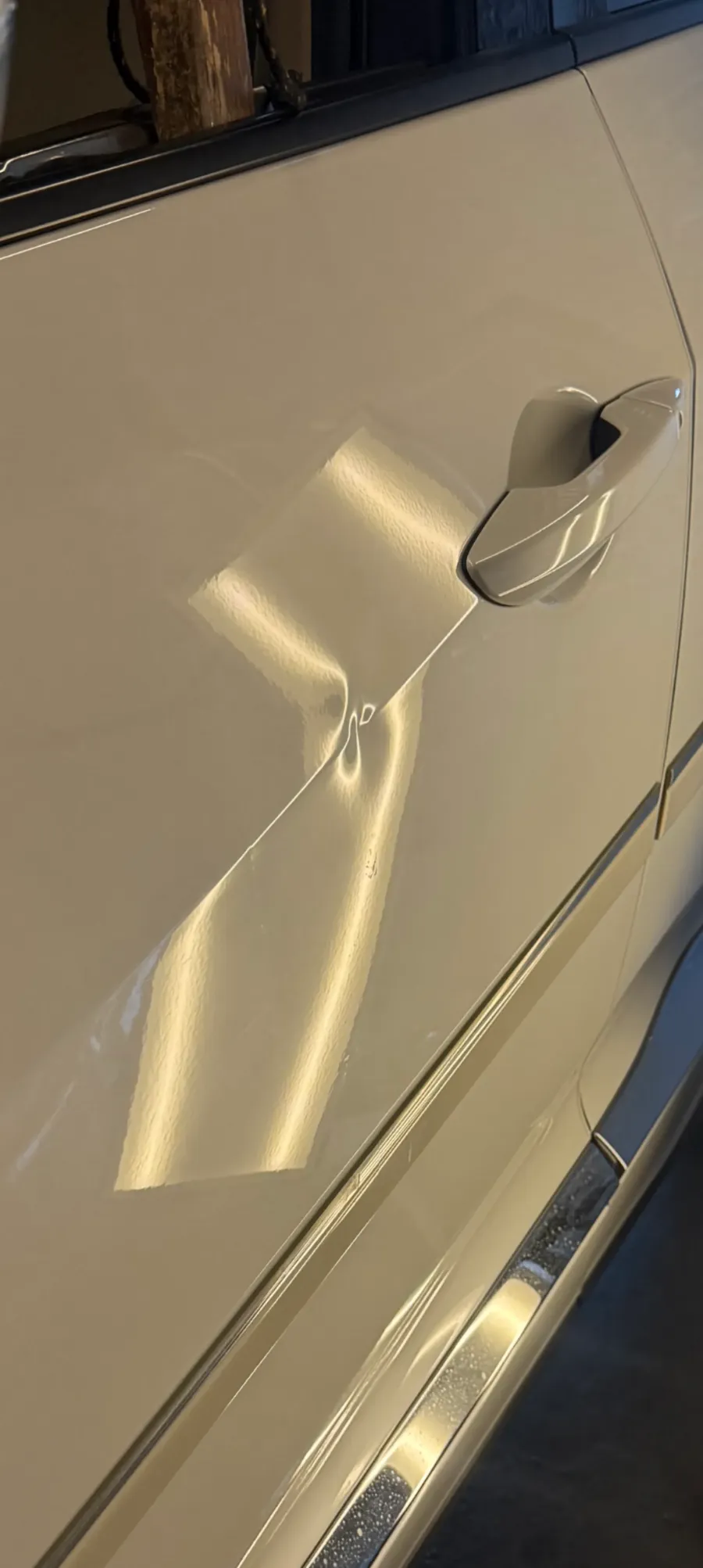 Paintless dent repair before and after on tan SUV rear door crease near handle in Garland TX