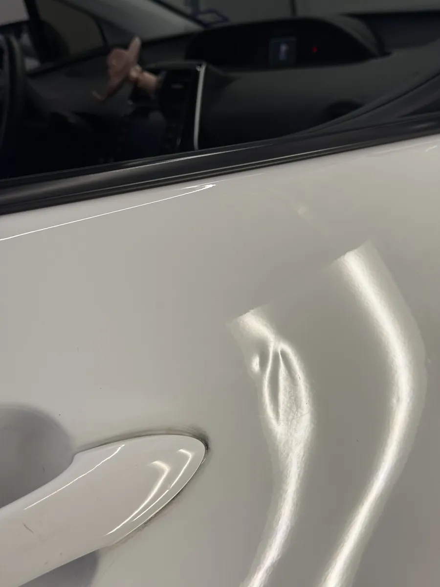 Paintless dent repair before and after on vehicle body panel in Garland TX