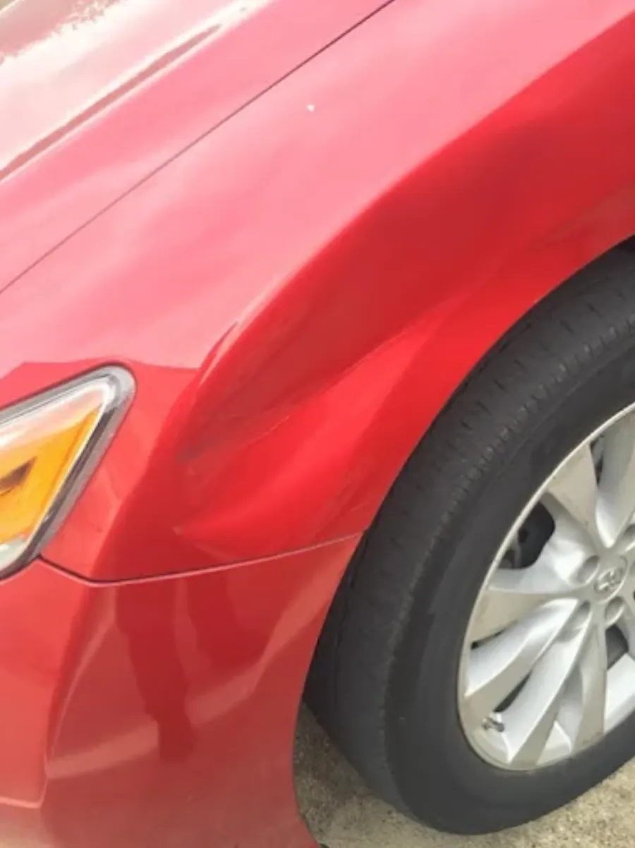 Paintless dent repair before and after on red vehicle fender in Garland TX