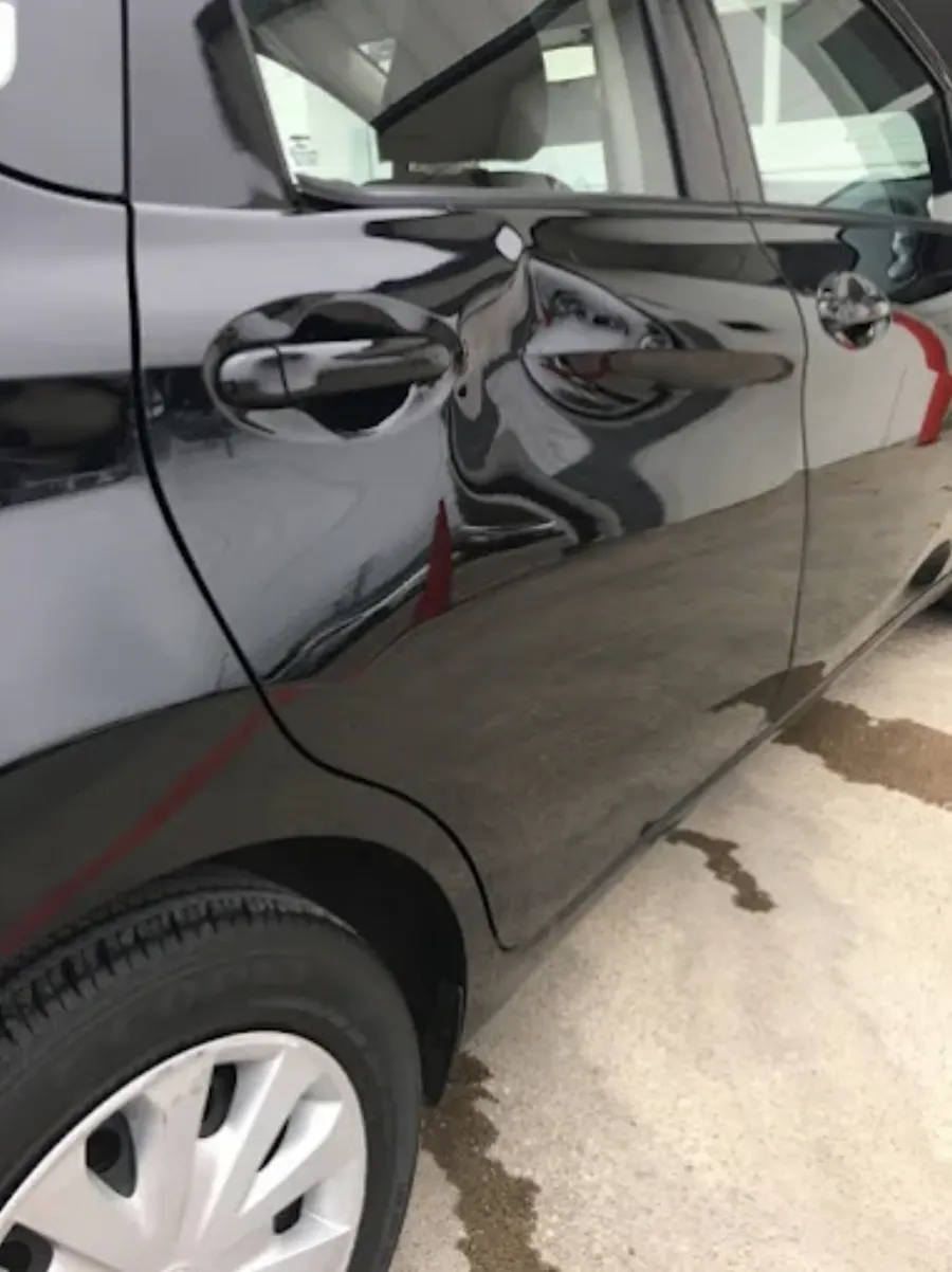 Paintless dent repair before and after on black vehicle door in Garland TX