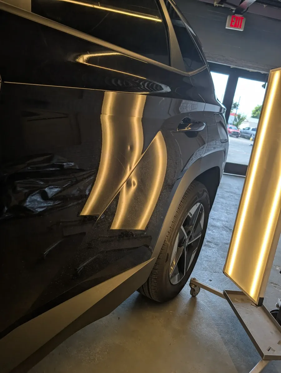 Paintless dent repair before and after on black Hyundai Tucson rear door and quarter panel in Garland TX